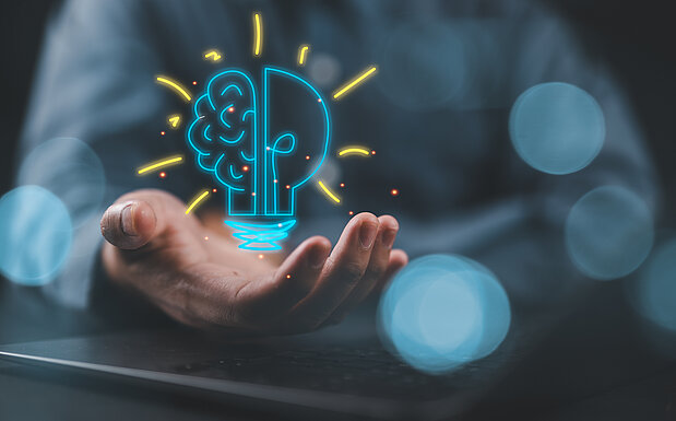 Visualisierung einer Idee. Mann hält eine gezeichnete Glühbirne in der Hand.